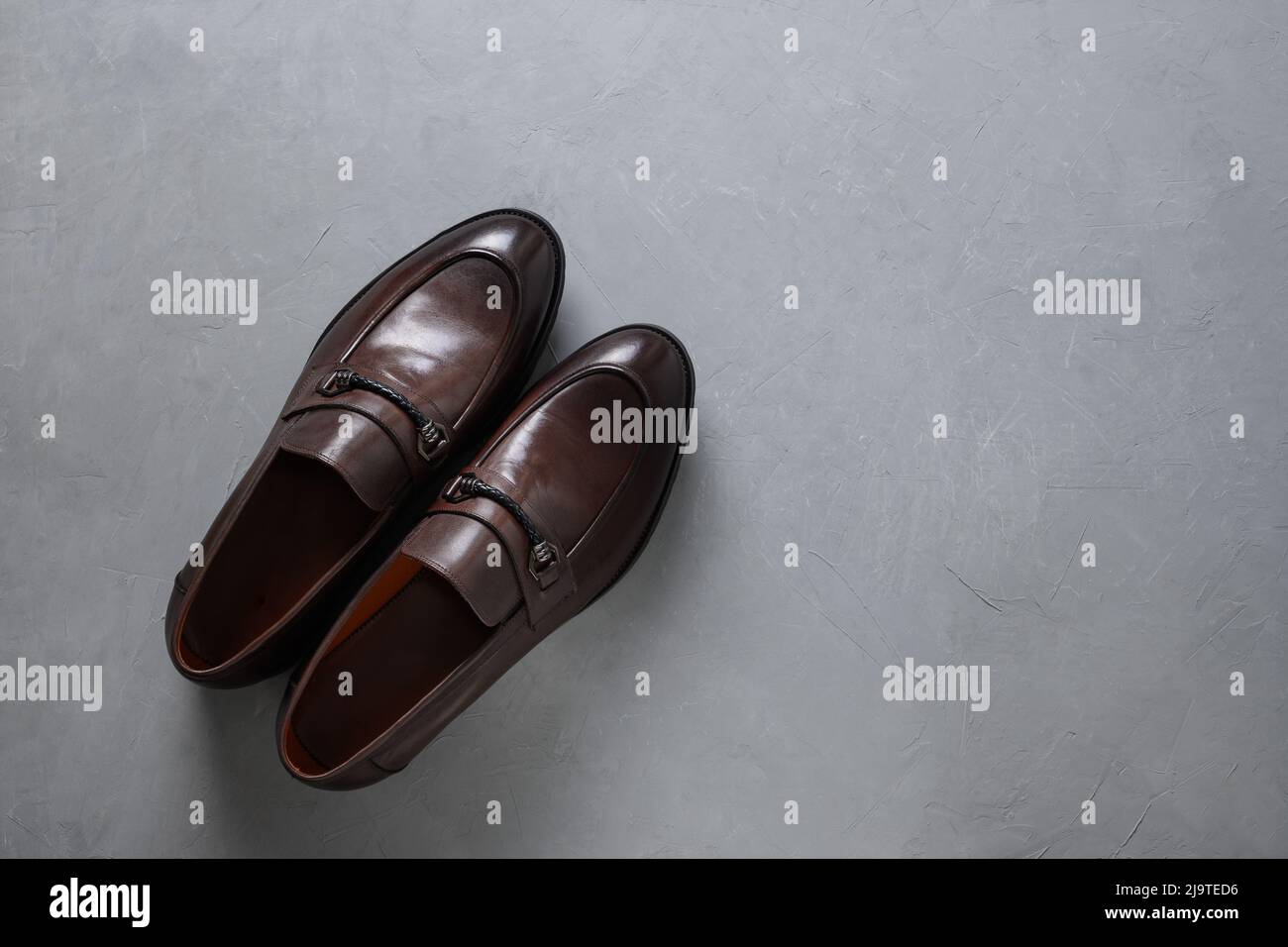 Scarpe classiche marroni da calzare maschio su sfondo grigio. Vista dall'alto. Spazio di copia. Foto Stock