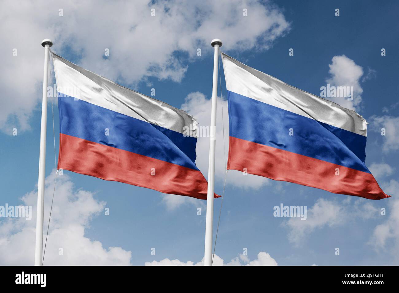 Russia e Russia due bandiere su flagpoli e sfondo blu cielo nuvoloso Foto Stock