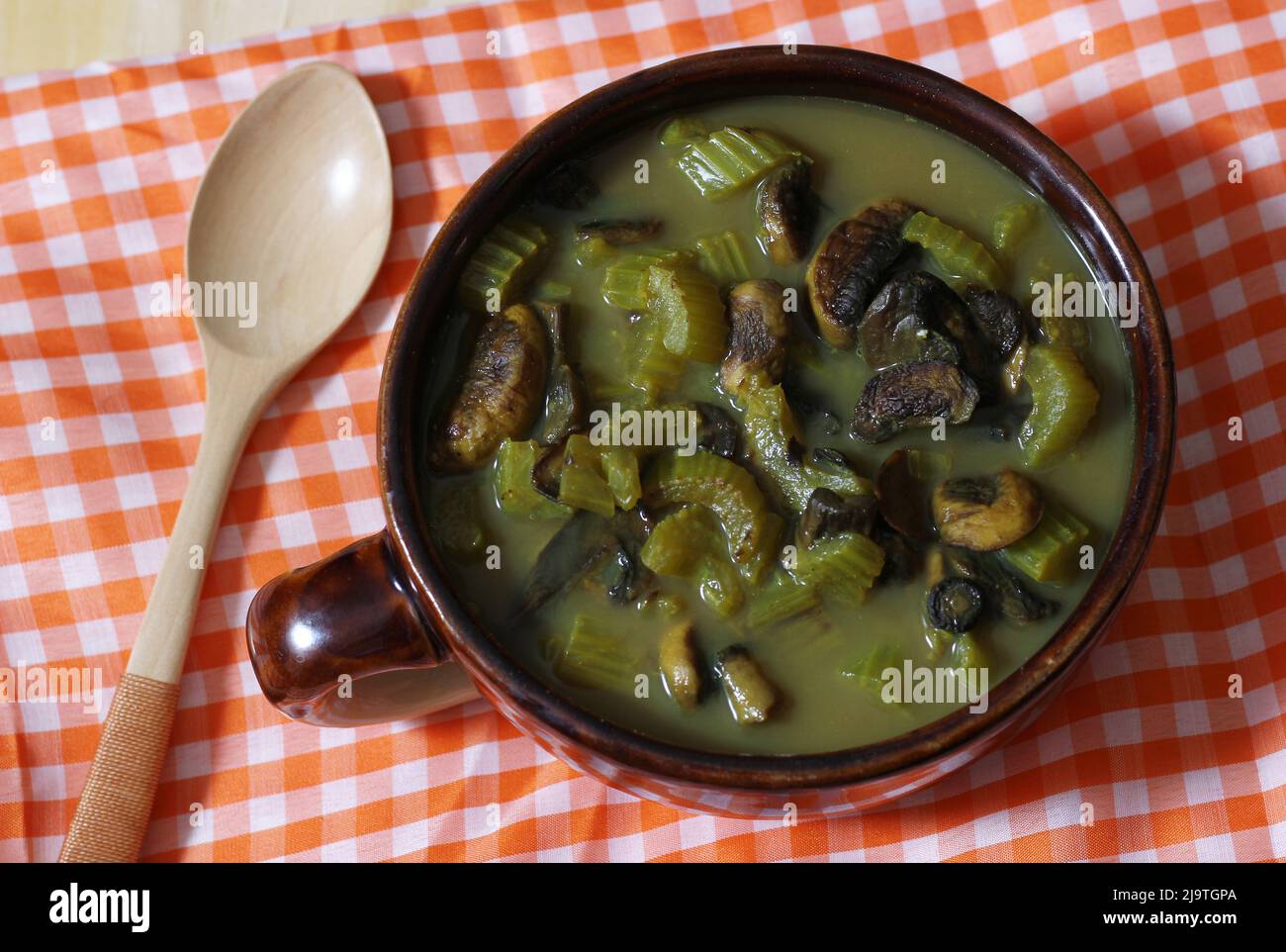 Sostanziosa zuppa di funghi e sedano con brodo vegetale piccante in cucina rustica Foto Stock
