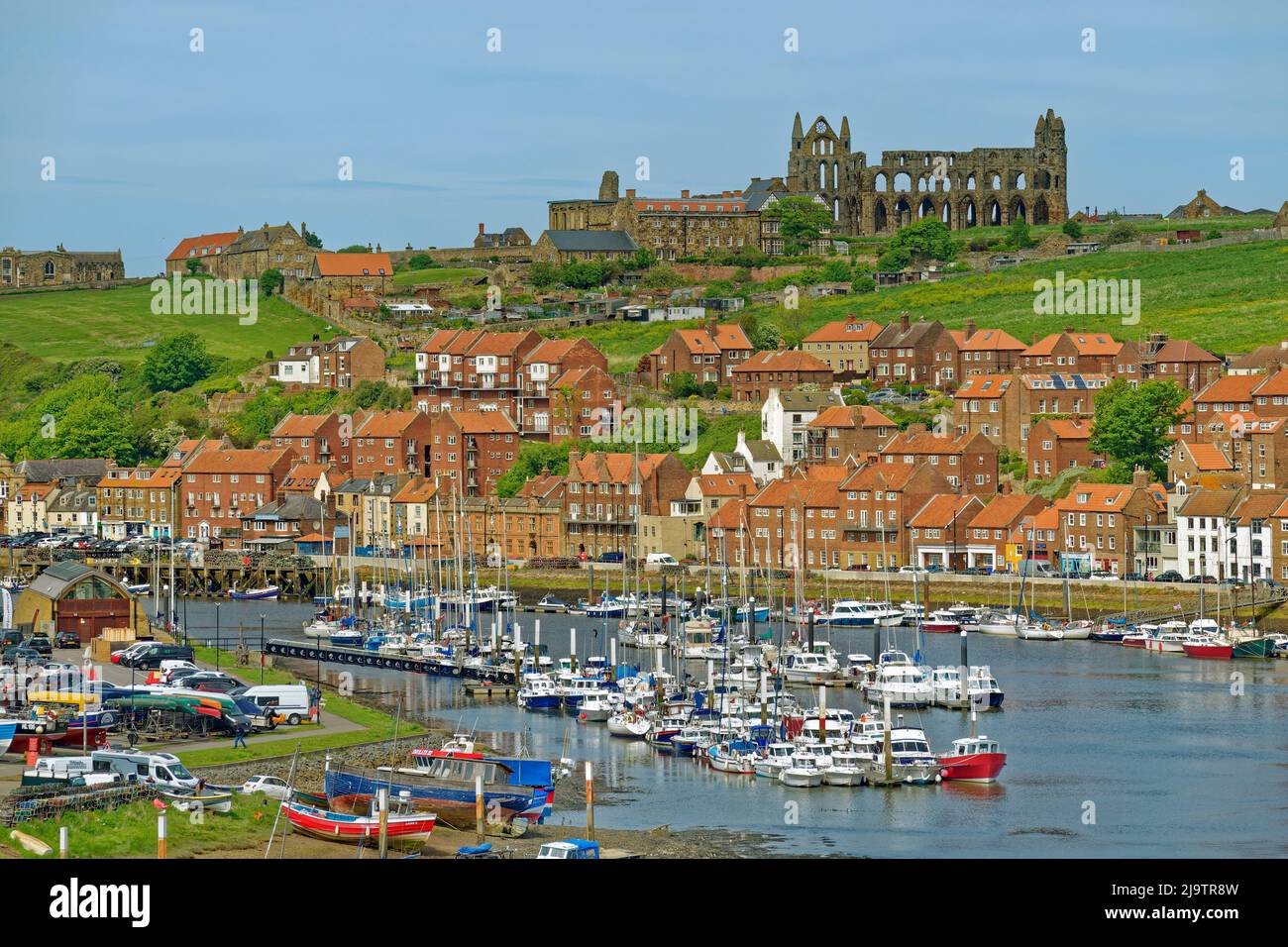 Whitby East Cliff con Whitby Abbey Beyond e Whitby marina sul fiume Esk in primo piano, North Yorkshire, Inghilterra. Foto Stock