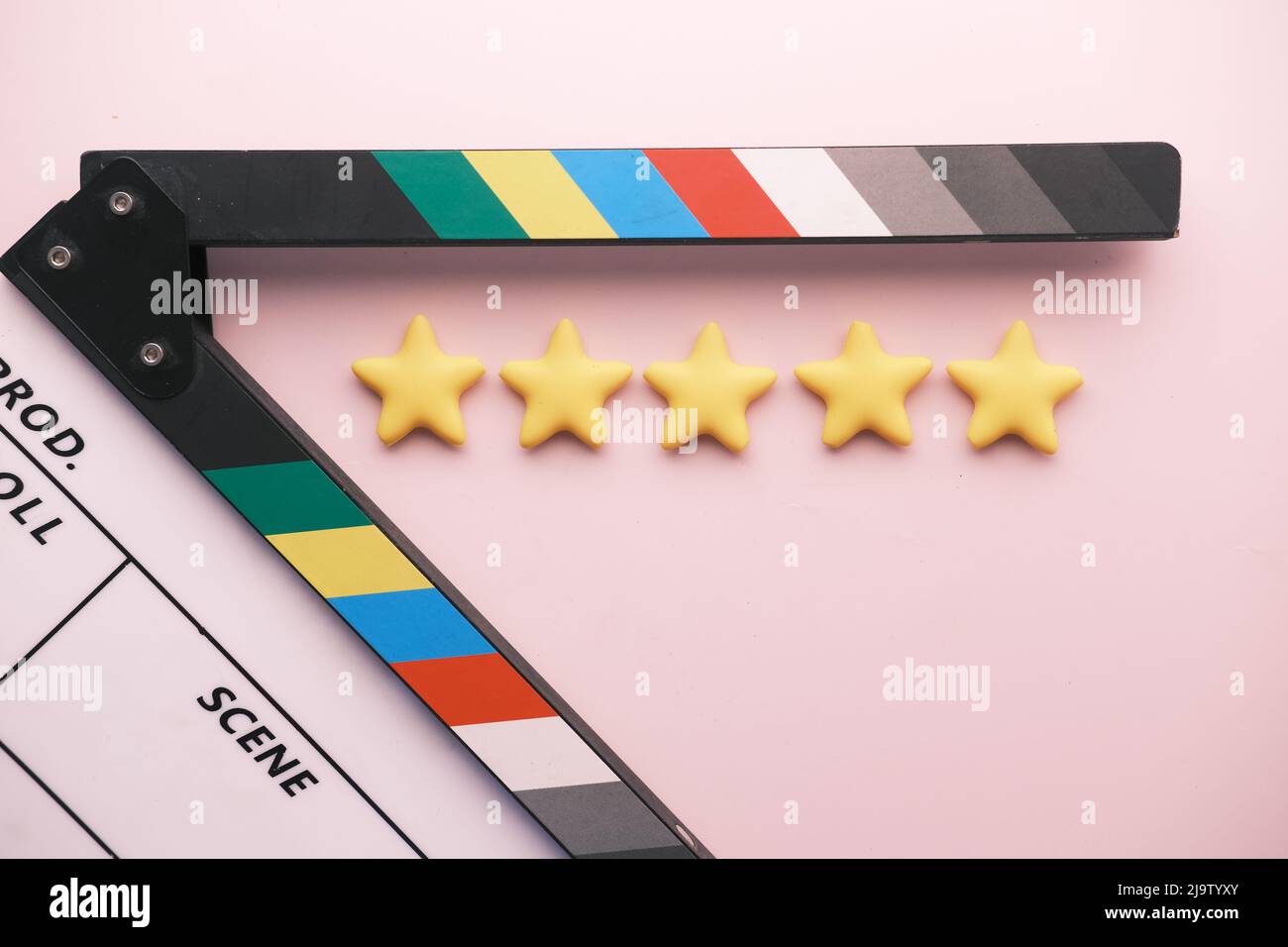 Stelle dorate e scheda clapper film su sfondo a colori Foto Stock