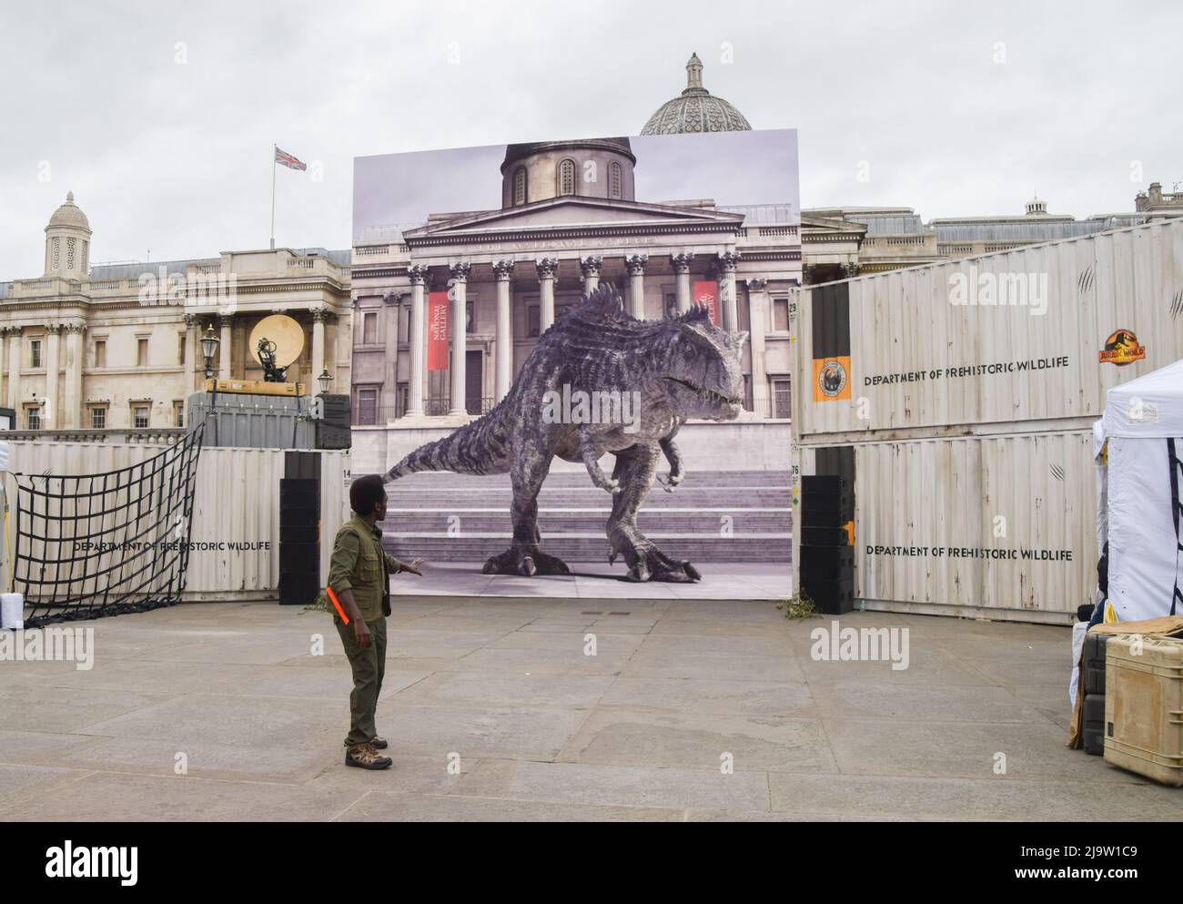 Londra, Regno Unito. 25th maggio 2022. Un membro dello staff con il dinosauro. Un dinosauro interattivo su uno schermo gigante ha intrattenuto i fan di Trafalgar Square prima dell'uscita del prossimo film Jurassic World Dominion. Credit: Vuk Valcic/Alamy Live News Foto Stock