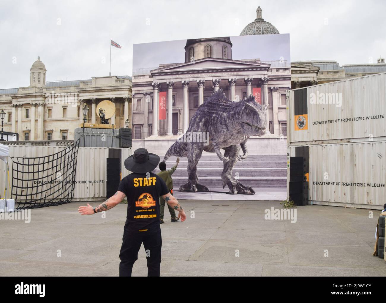 Londra, Regno Unito. 25th maggio 2022. Un membro dello staff con il dinosauro. Un dinosauro interattivo su uno schermo gigante ha intrattenuto i fan di Trafalgar Square prima dell'uscita del prossimo film Jurassic World Dominion. Credit: Vuk Valcic/Alamy Live News Foto Stock