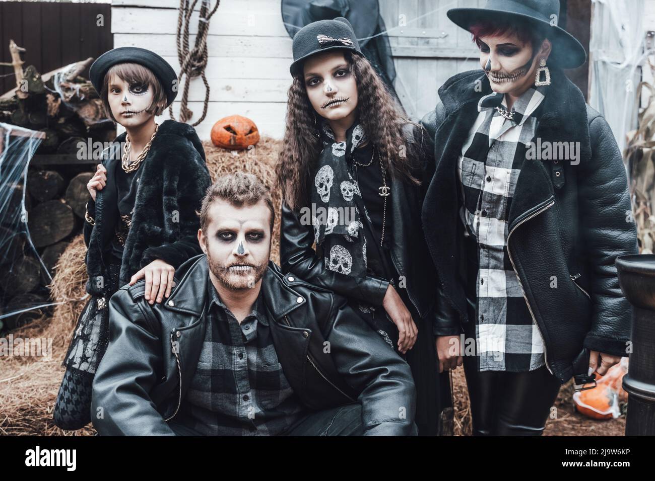 Famiglia spaventosa, madre, padre, figlie che celebrano Halloween. Terrificante cranio nero mezza faccia trucco e costumi strega, elegante images.Horror, divertimento a Foto Stock