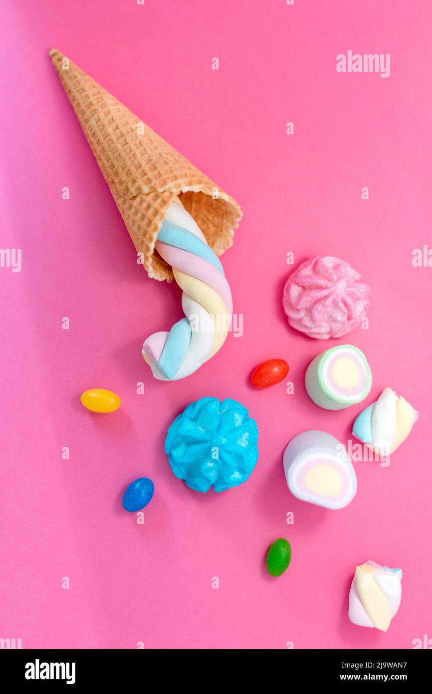 Marshmallow con cono waffle su sfondo rosa. Dolci, zucchero, caramelle, marshmallow e cono gelato. Spazio libero per la copia, colori pastello Foto Stock