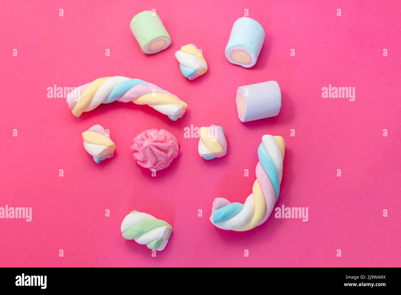 Marshmallow su sfondo rosa. Assortimento di caramelle e dolci su sfondo rosa. Marshmallow in colori pastello con spazio di copia Foto Stock