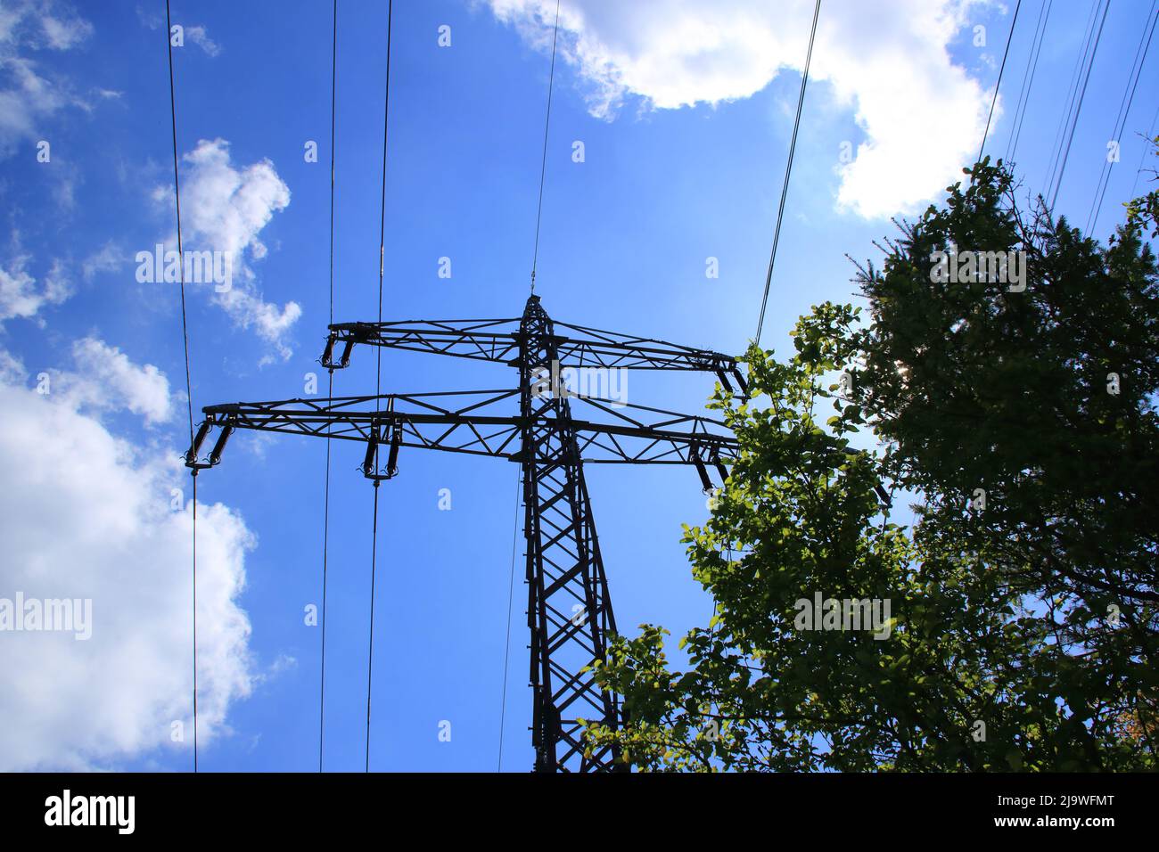 Singolo traliccio ad alta tensione contro un cielo blu Foto Stock