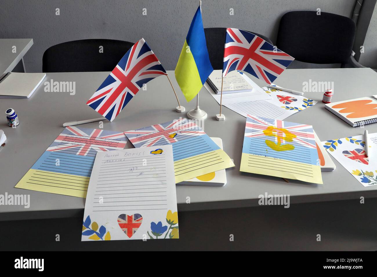 ODESA, UCRAINA - 25 MAGGIO 2022 - le bandiere da tavolo dell'Ucraina e del Regno Unito sono raffigurate vicino alle lettere dei bambini al primo ministro britannico Boris Johnson che ha Foto Stock