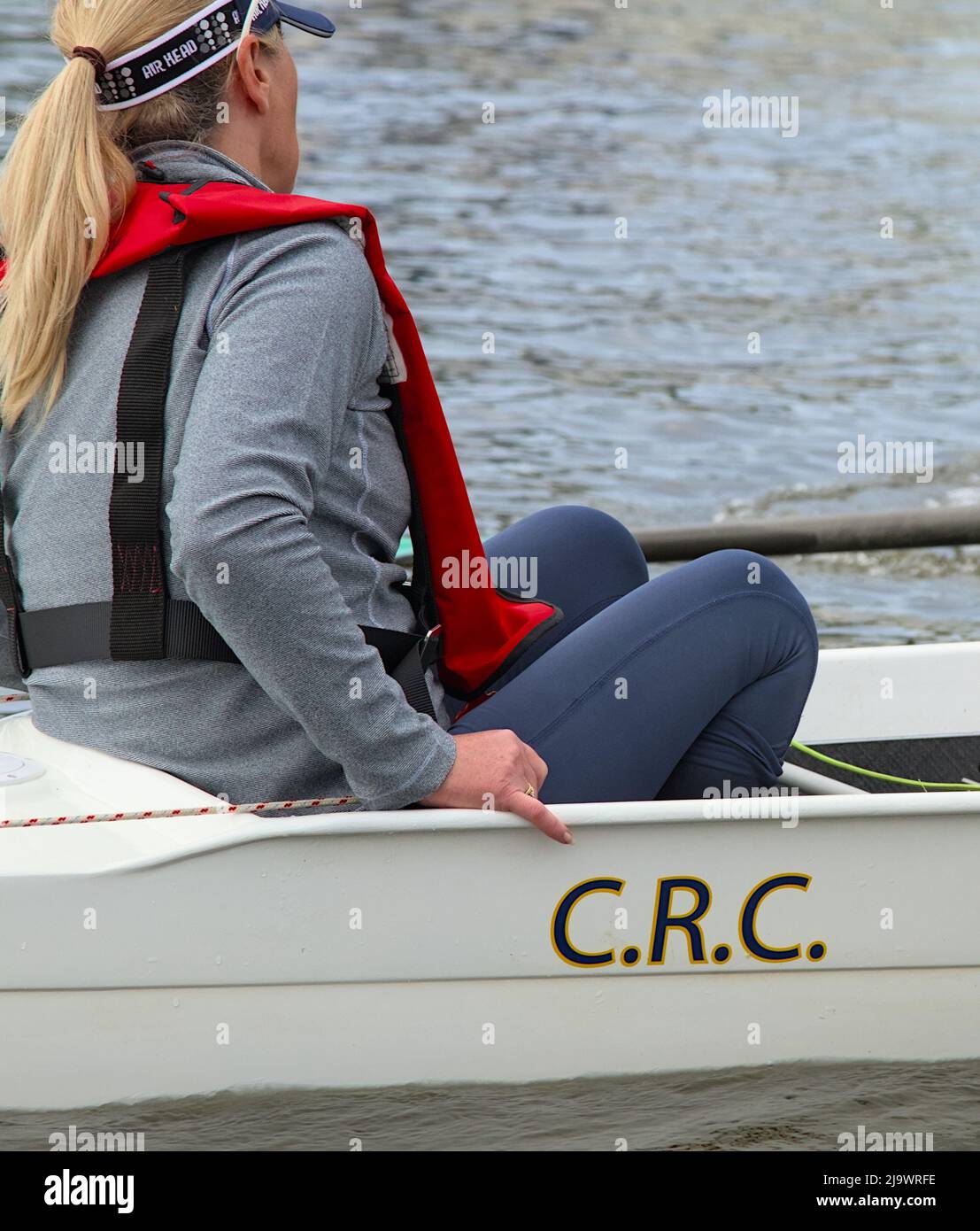 Donna Bow Cox su Una barca da traino Coxed Four Sweep Racing Shell con Christchurch Sailing Club Monogram, Regno Unito Foto Stock