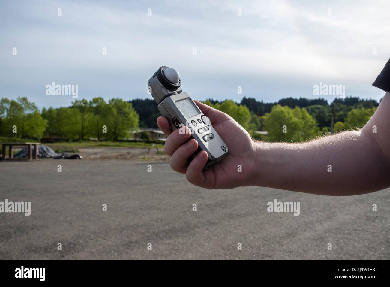 Seattle, WA USA - circa Maggio 2022: Vista di un uomo che tiene un misuratore di luce Sekonic mentre fotografa all'aperto Foto Stock