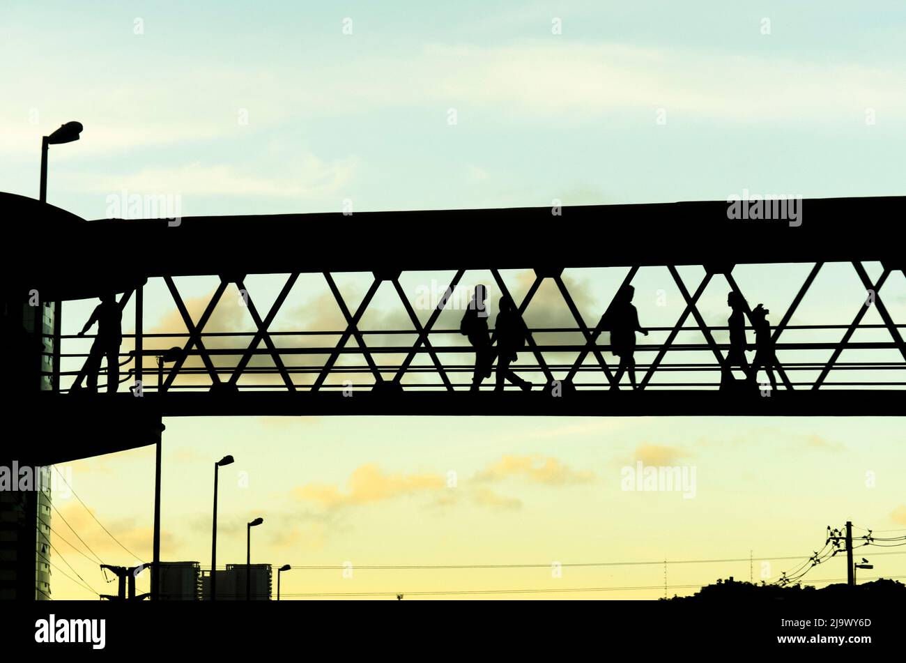 Salvador, Bahia, Brasile - 26 gennaio 2015: Pedoni in silhouette camminando sulla passerella contro il tramonto nella città di Salvador, capitale di Bahia, Brasile. Foto Stock