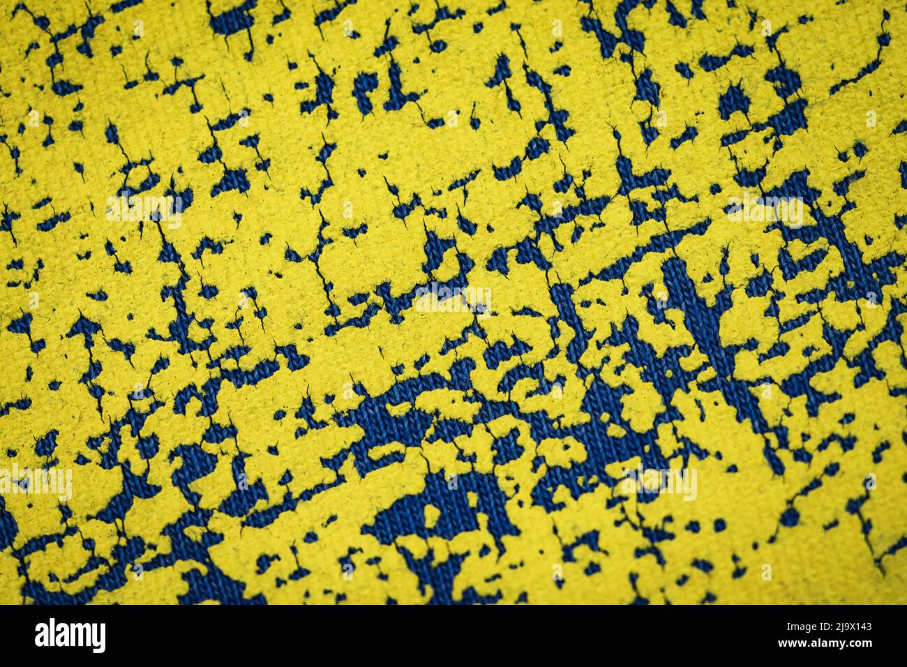 sfondo astratto vecchio colore giallo cracked su tessuto blu Foto Stock