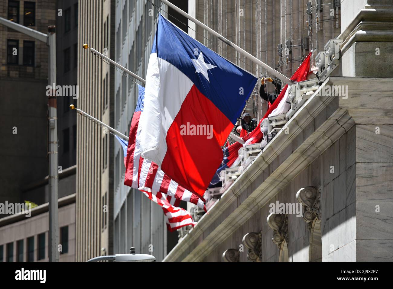 La bandiera americana e la bandiera di stato del Texas in mostra fuori della Borsa di New York (NYSE) il 25 maggio 2022 a New York Foto Stock