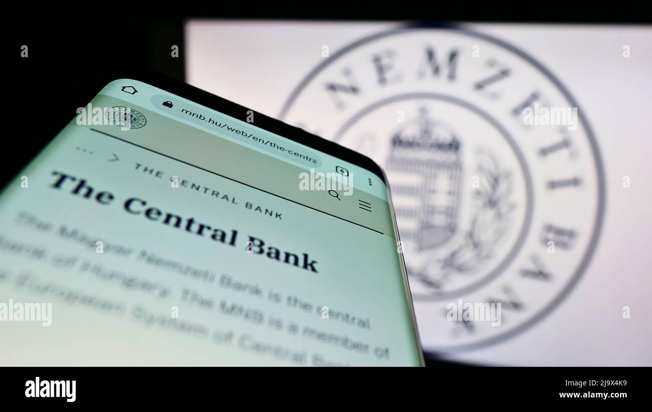 Telefono cellulare con sito web della Banca Nazionale Ungherese (Magyar Nemzeti Bank, MNB) sullo schermo di fronte al logo. Mettere a fuoco sulla parte superiore sinistra del display del telefono. Foto Stock