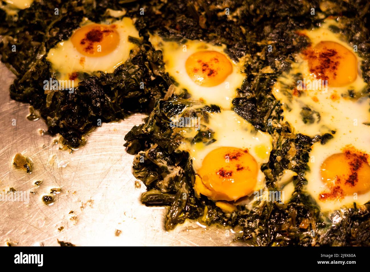 Contenitore a buffet riscaldato con uova con spinaci e aglio Foto Stock