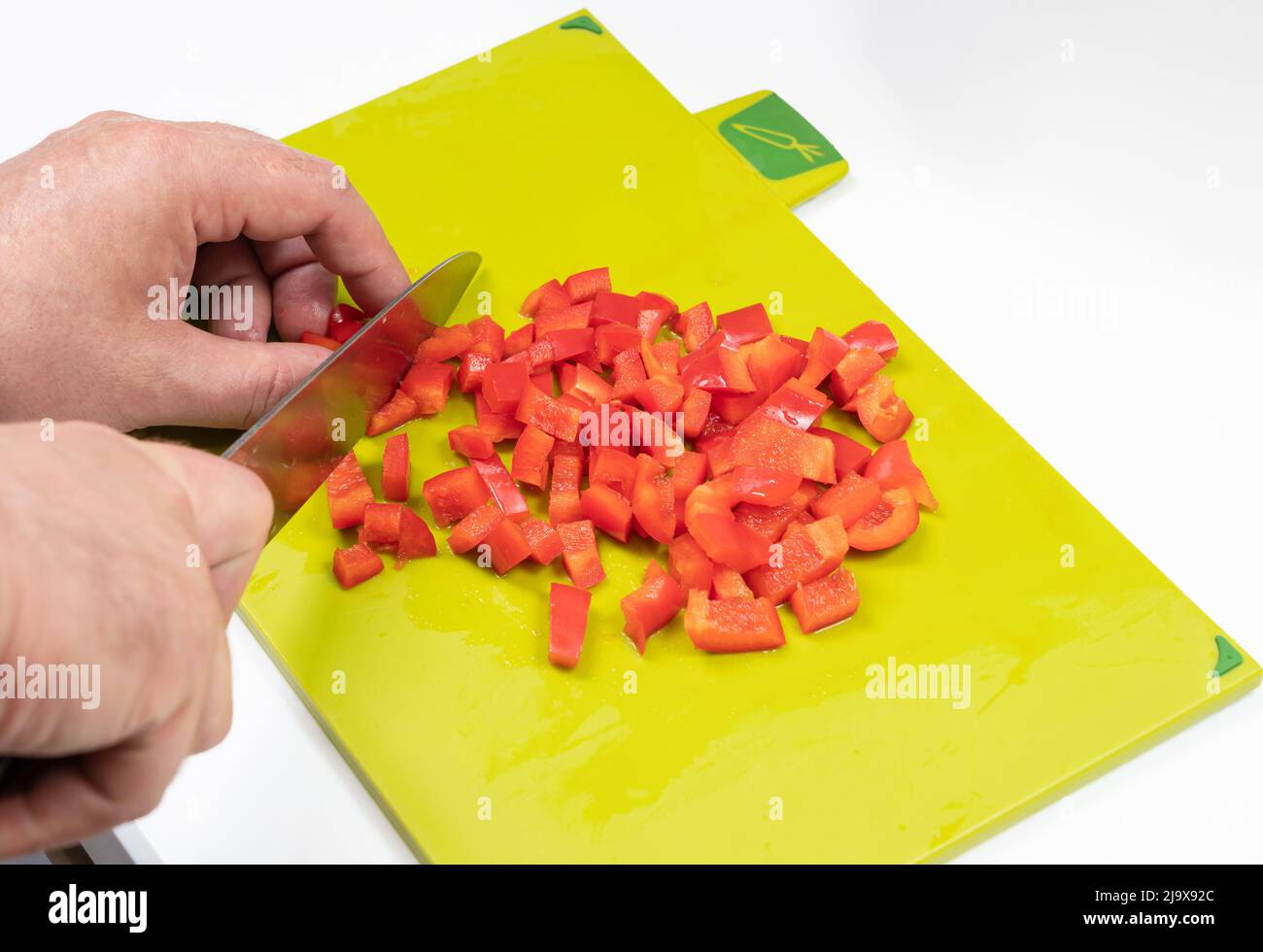 preparazione dell'insalata di peperoni con le mani degli uomini Foto Stock