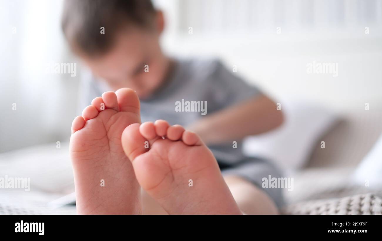 Primo piano delle gambe dei bambini con i piedi in avanti Foto Stock