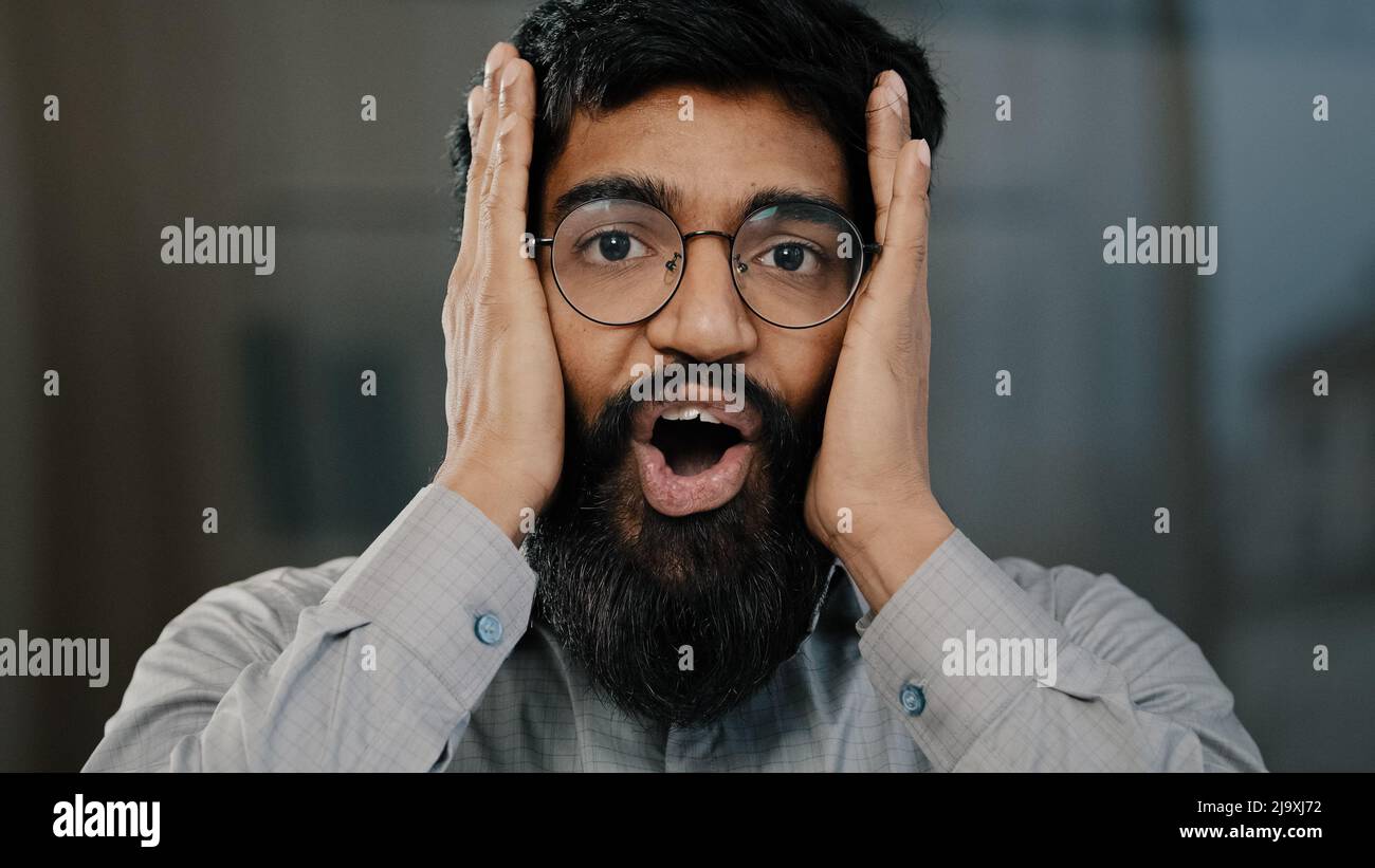 Scioccato sorridente uomo arabo agente professionale uomo d'affari in occhiali sorpreso buona notizia sorprendente scoprire sentire emotivo stupore dire WOW Foto Stock