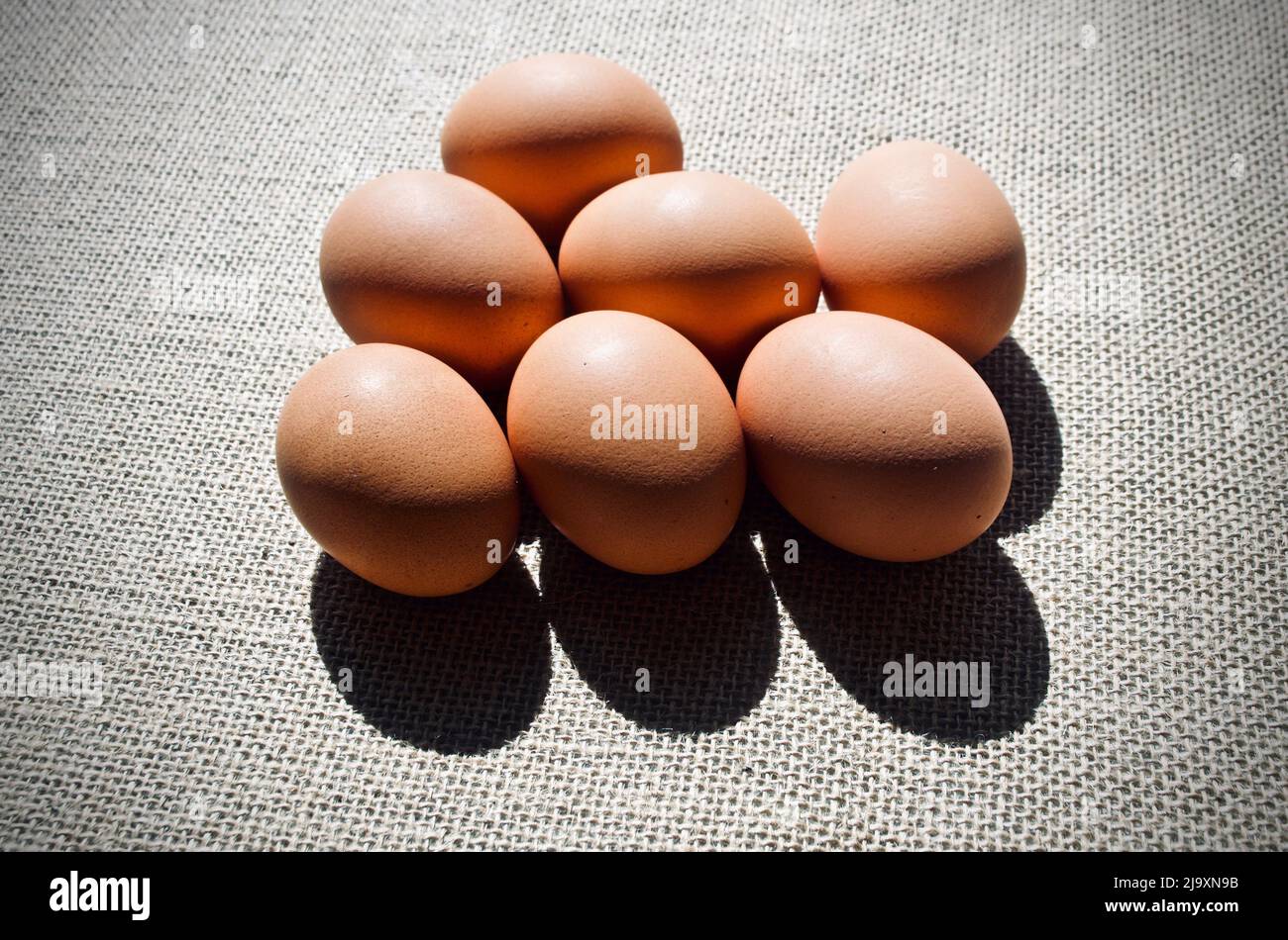Uova su sacco marrone su sfondo scuro Foto Stock