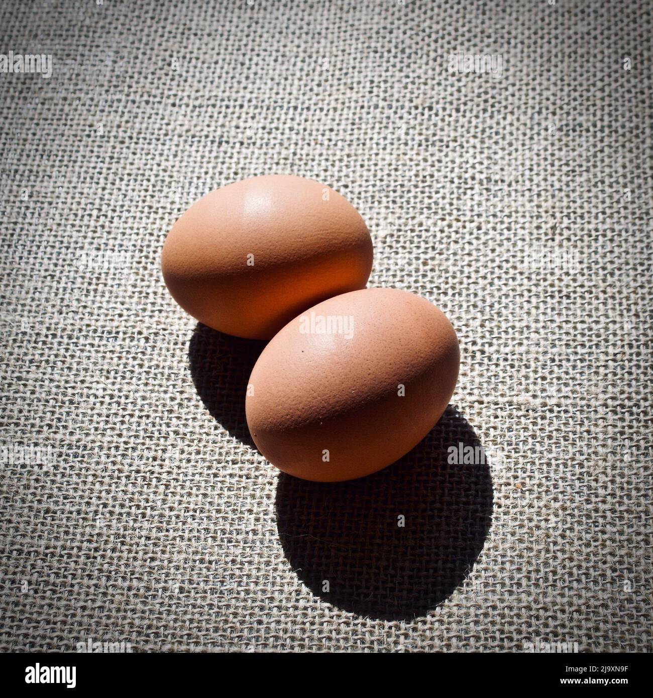 Uova su sacco marrone su sfondo scuro Foto Stock