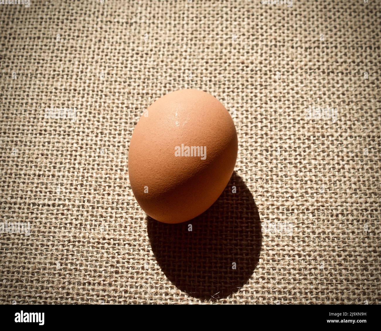 Uova su sacco marrone su sfondo scuro Foto Stock