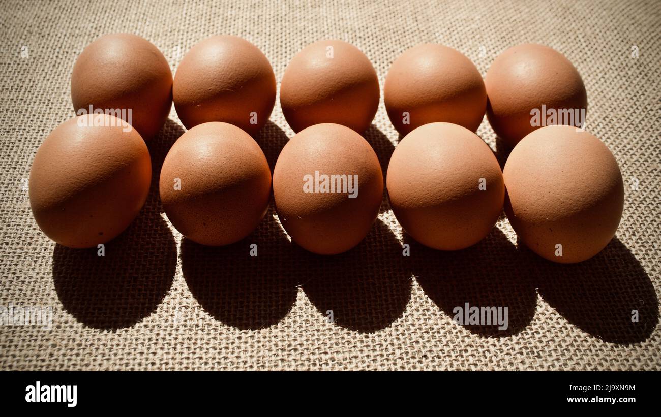 Uova su sacco marrone su sfondo scuro Foto Stock