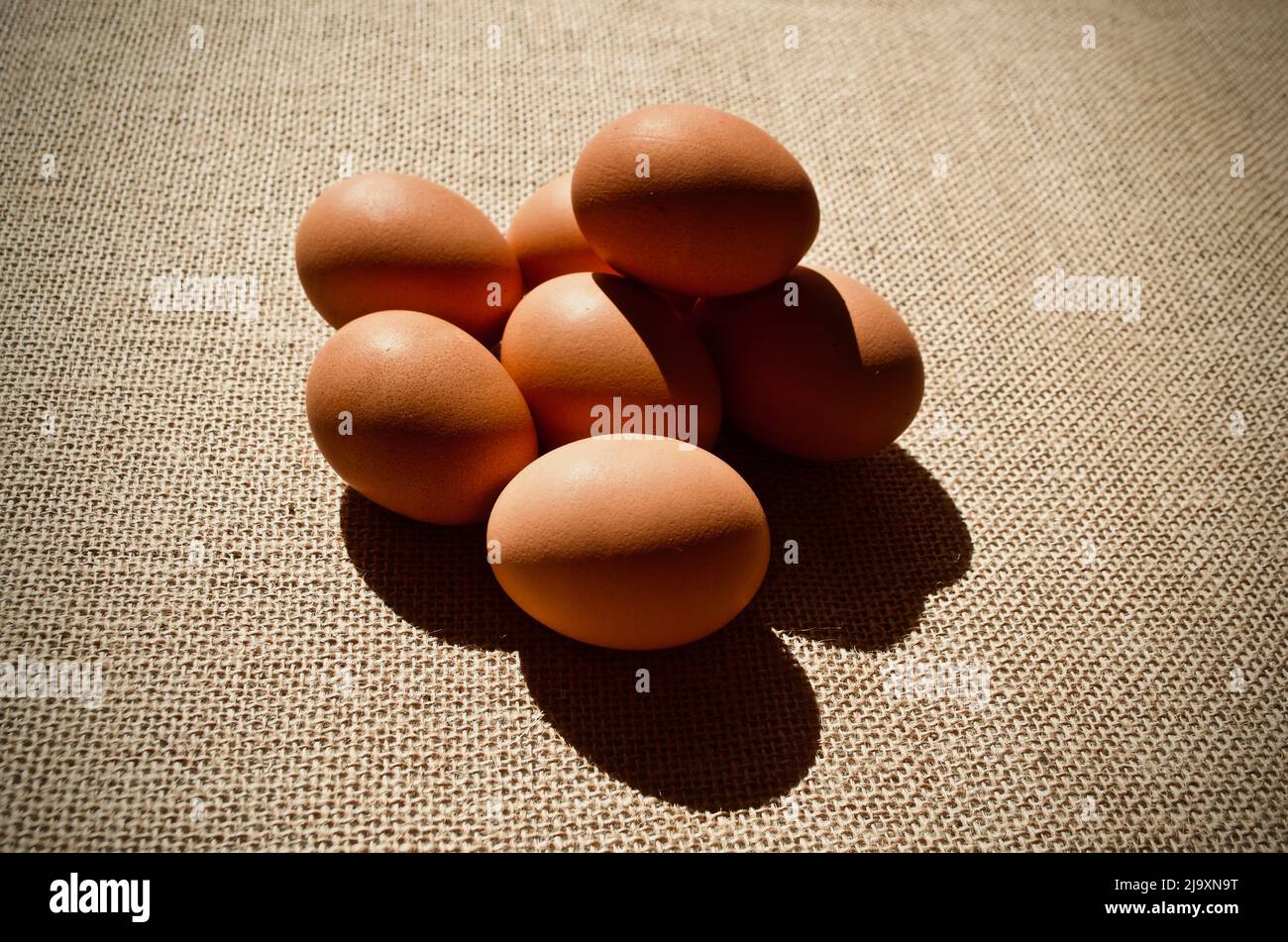Uova su sacco marrone su sfondo scuro Foto Stock