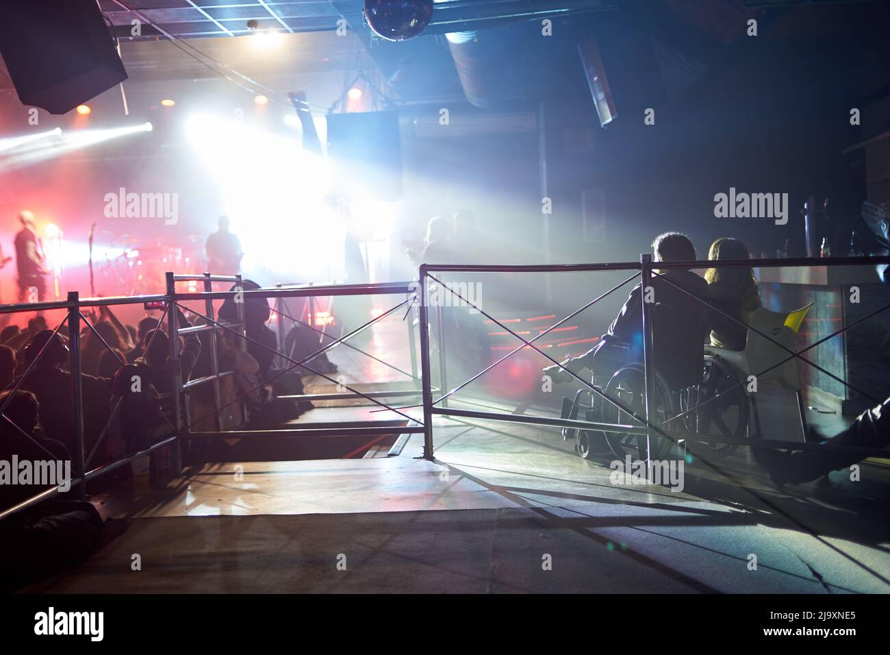 Persona in sedia a rotelle che guarda un concerto in un festival di musica dal vivo Foto Stock