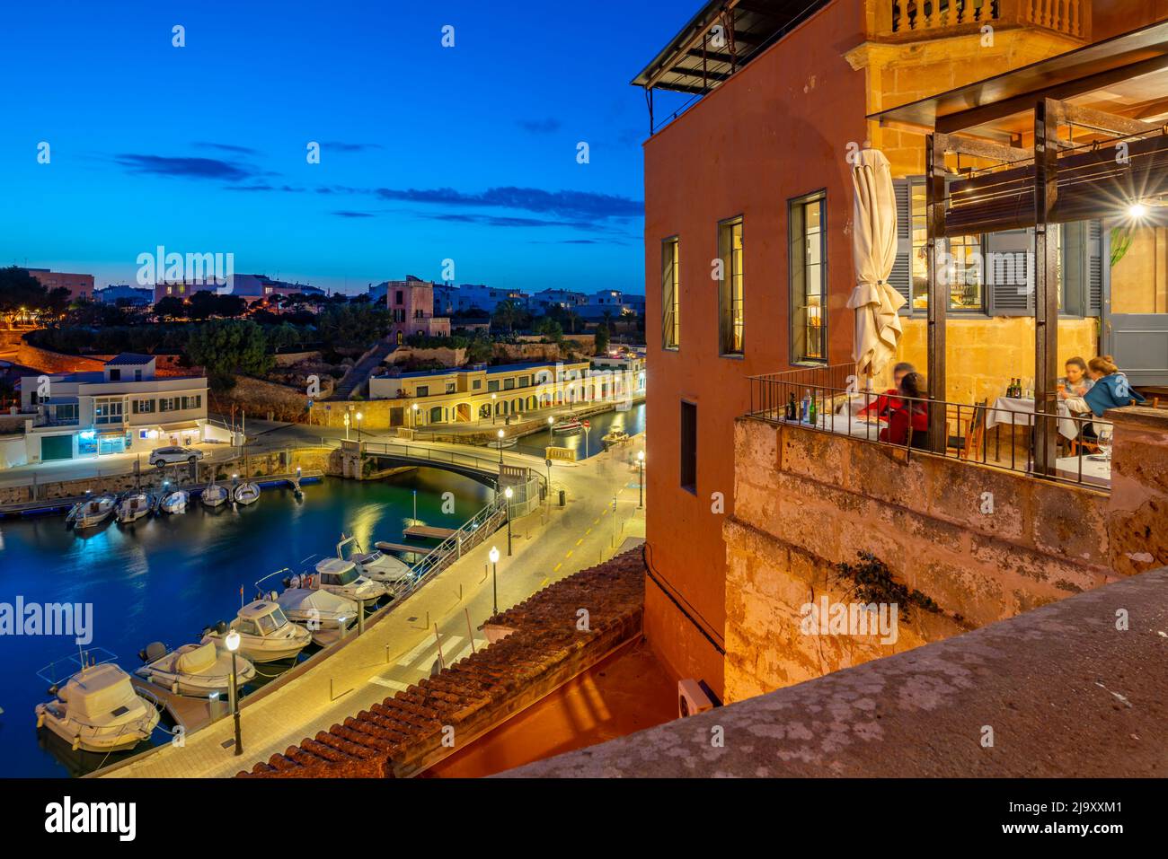 Vista del ristorante balcone e porto turistico al tramonto da posizione elevata, Ciutadella, Memorca, Isole Baleari, Spagna, Europa Foto Stock