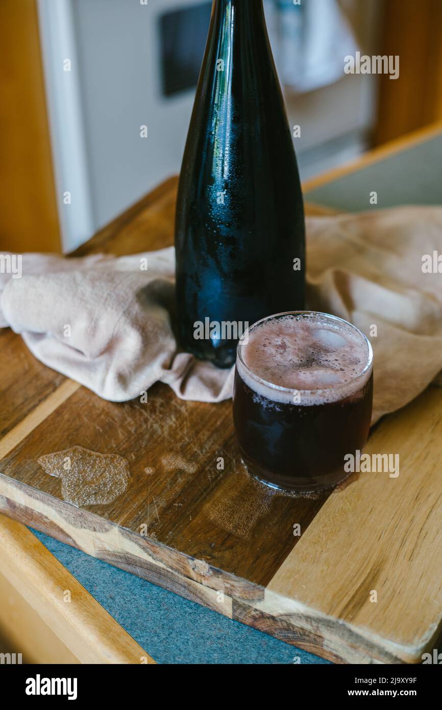 Una bottiglia di vino rosso e un cocktail pronto per bere Foto Stock