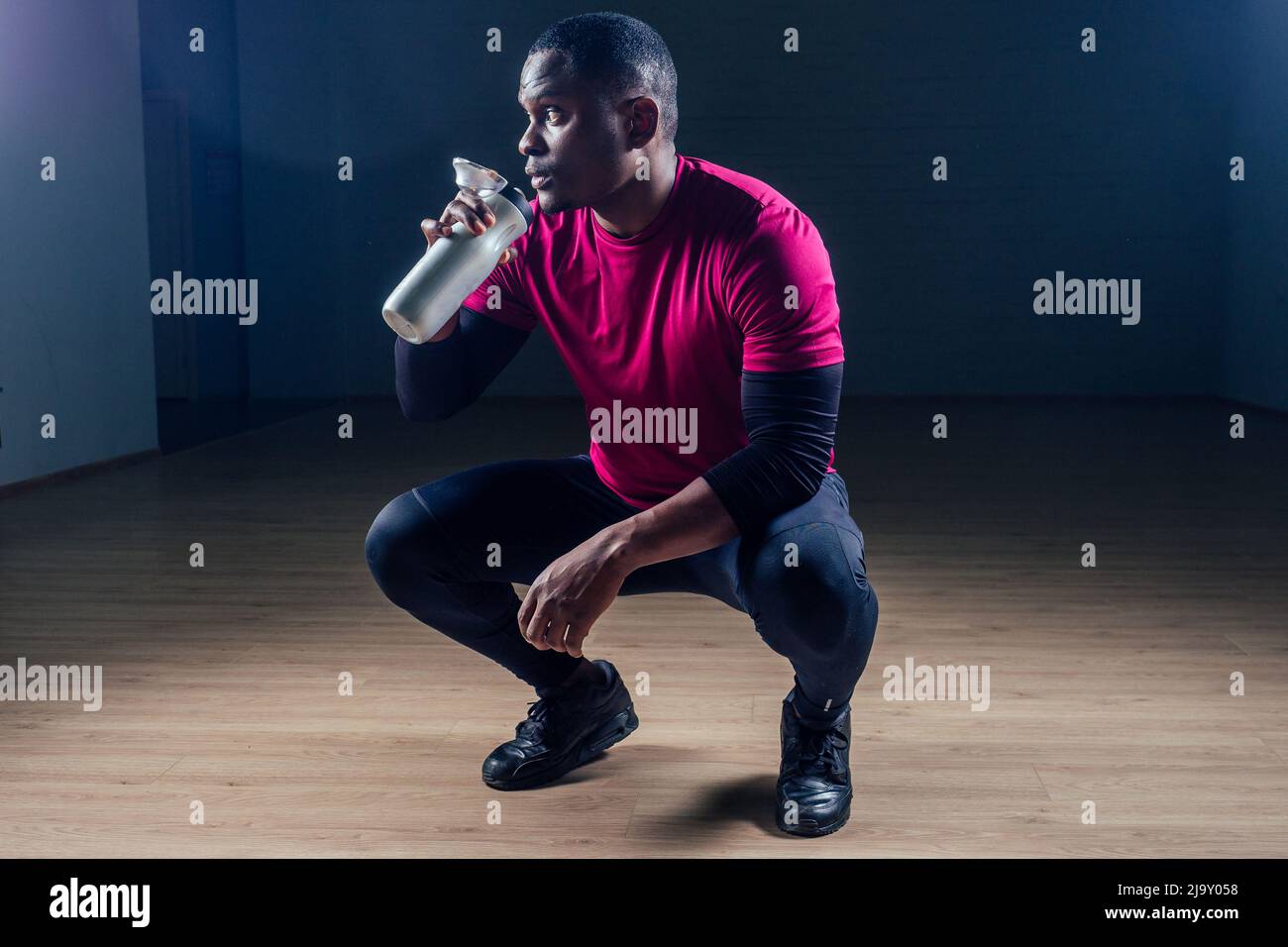 ritratto di un giovane pugile sportivo africano americano su sfondo nero pugile pericoloso sguardo minaccioso colpito Foto Stock