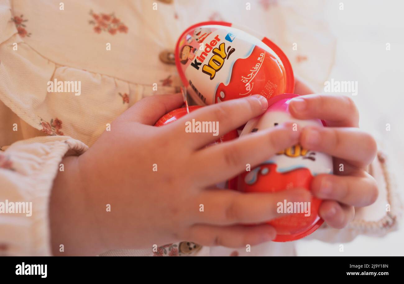 Cairo Egitto. 22. Aprile 2022 piccola ragazza tiene cioccolato Kinder sorpresa Egg. Gustoso cioccolato presente per bambini. dente dolce. Foto Stock