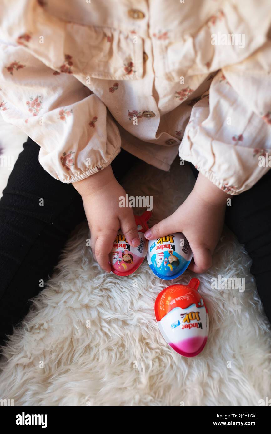 Cairo Egitto. 22. Aprile 2022 piccola ragazza tiene cioccolato Kinder sorpresa Egg. Gustoso cioccolato presente per bambini. dente dolce. Foto Stock