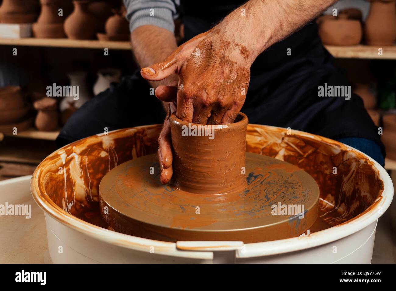 potter professionista uomo felice che lavora con argilla marrone in officina. imprenditore artista commercio negozio di pentola fatto a mano Foto Stock