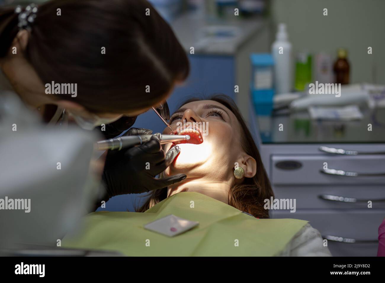 Il processo di rimozione braces.Beautiful donna in sedia dentale durante la procedura di installazione bretelle ai denti superiore e inferiore. Dentista e assistente w Foto Stock