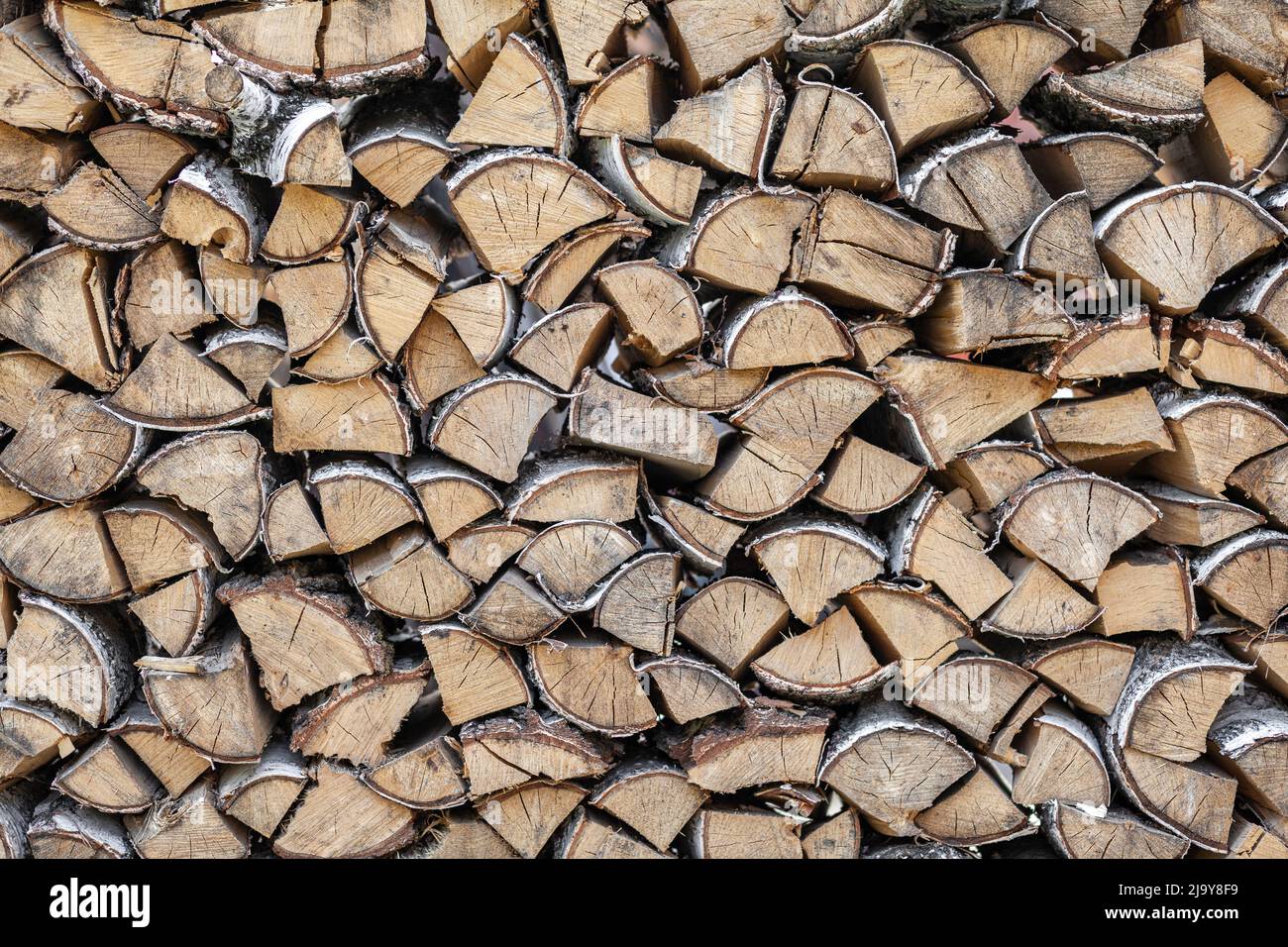 Legna da ardere di fondo di legno tritato per accendere e riscaldare la casa Close-up. Un mazzo di legno con legna da ardere accatastata. La tessitura dell'albero di betulla. bann Foto Stock