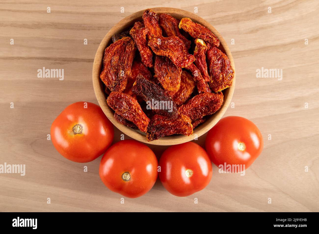 Pomodori freschi e pomodori secchi con fondo in legno Foto Stock