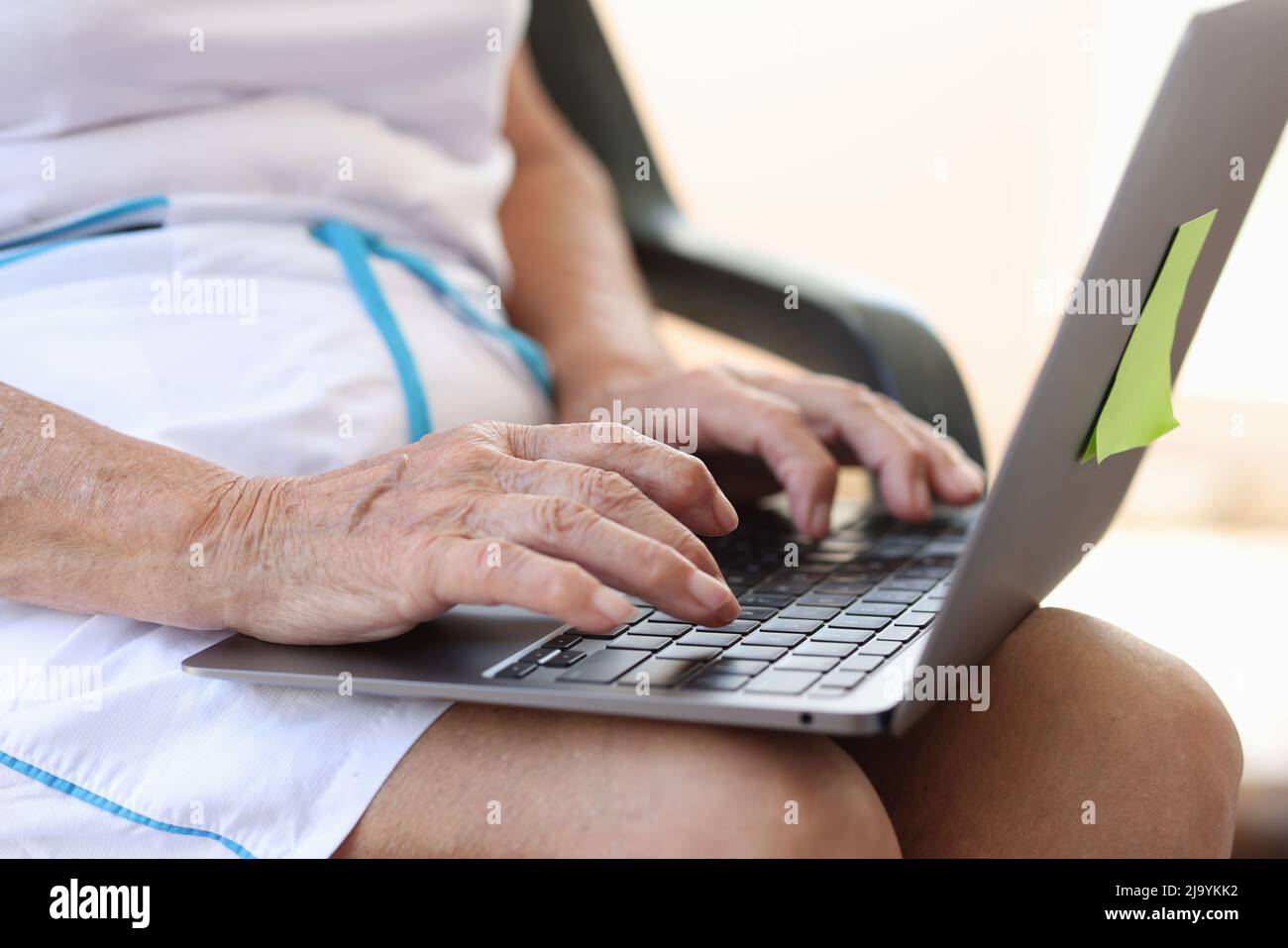 Le mani di una donna anziana matura stanno digitando sul laptop Foto Stock