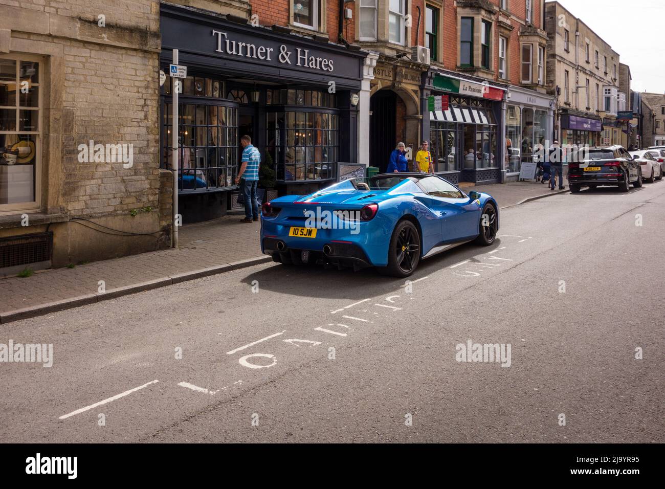 Blue Ferrari auto sportiva di lusso parcheggiata a Caricando solo area contrassegnata, Cirencester, Gloucestershire, Regno Unito Foto Stock