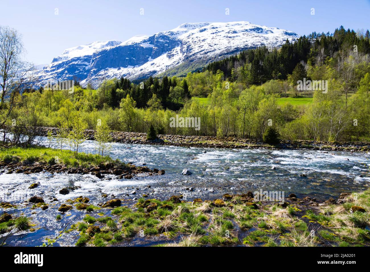 Fiume Loelva dal lago Lovatnet al Nordfjord, e montagne innevate. Loen, Norvegia Foto Stock