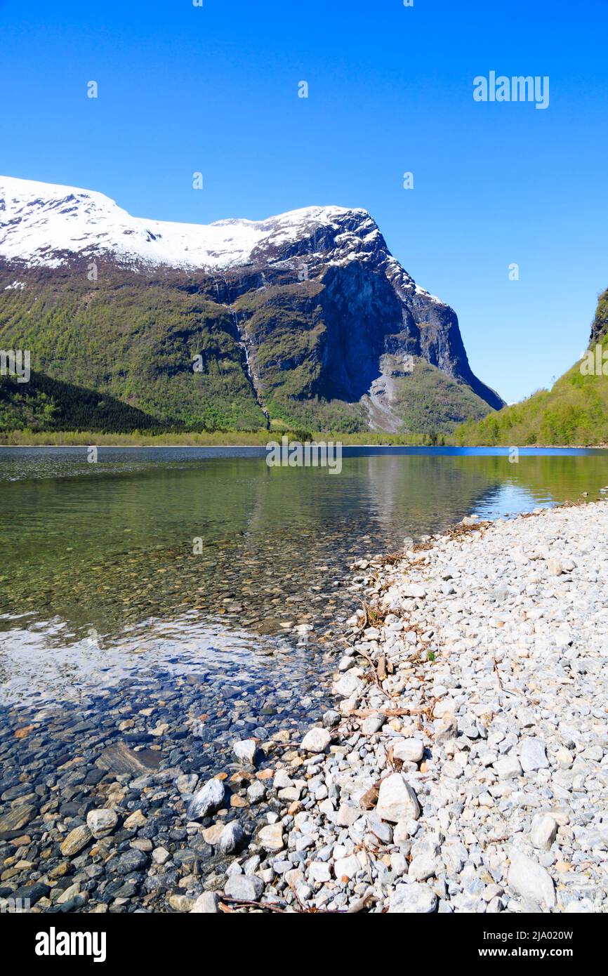 Vista sul lago Lovatnet da Kjenndalstova, Norvegia. Cime di montagna innevate e acqua blu limpida. Foto Stock