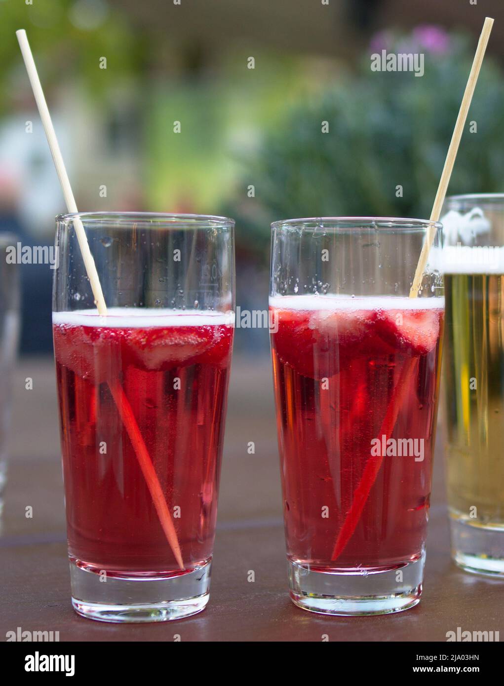Maibohle rosso con fragole bere con polvere di legno birra vetro verde tavola legno scuro Foto Stock
