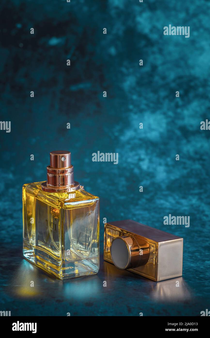 Bottiglia di profumo in vetro giallo/dorato con coperchio estratto su  sfondo blu Foto stock - Alamy