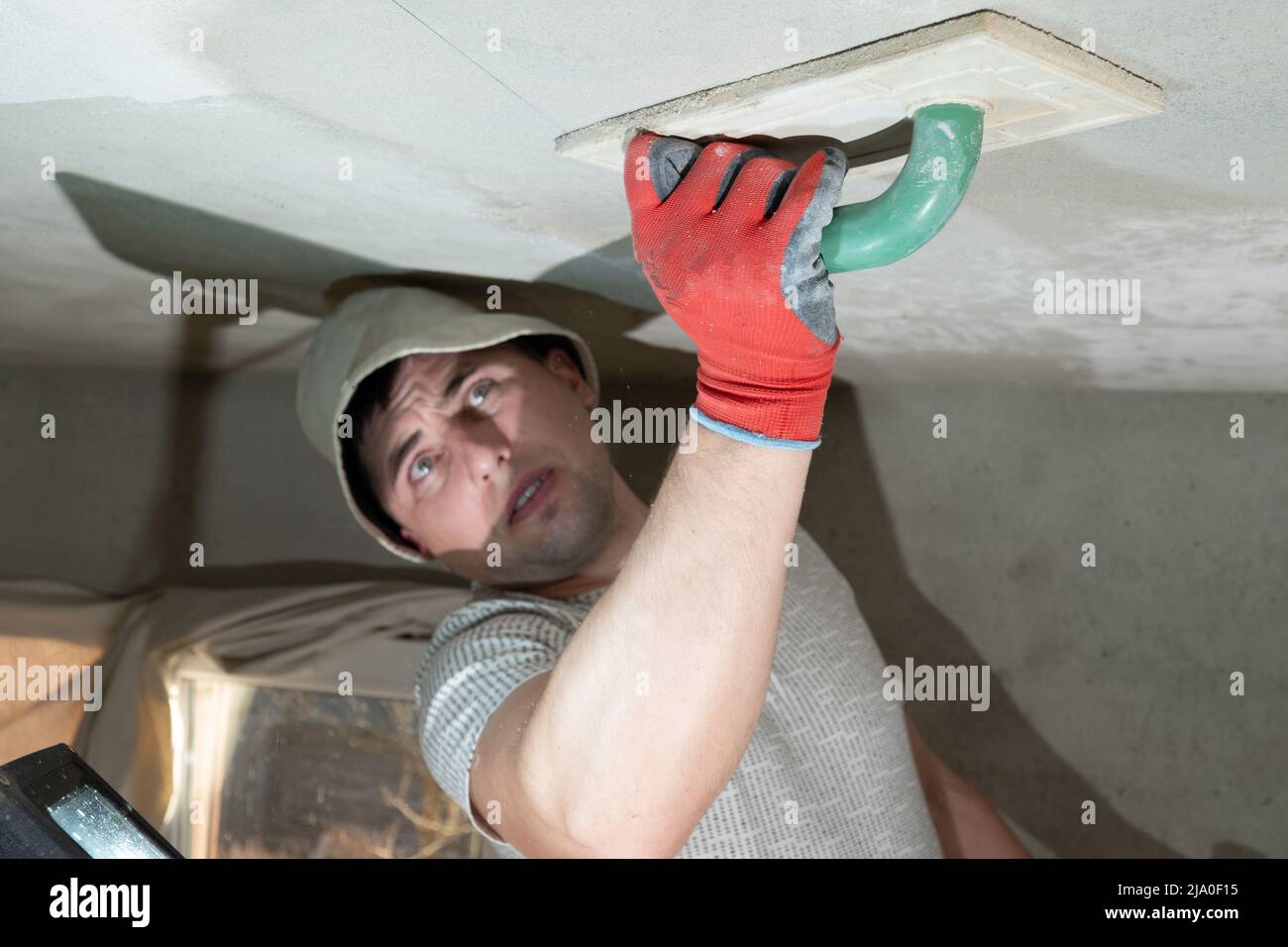 Il maestro sfrega il soffitto con una grattugia che assorbe l'umidità per  intonaco di calce, opera di riparazione egli stesso Foto stock - Alamy