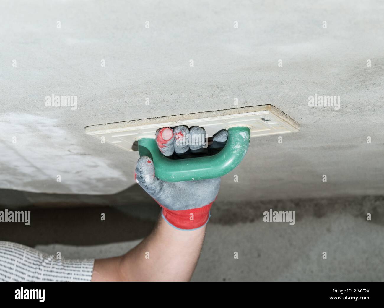 Livellando l'intonaco di calce con una grattugia con una spugna che assorbe  l'umidità, il maestro strofina il soffitto con una grattugia da costruzione  Foto stock - Alamy