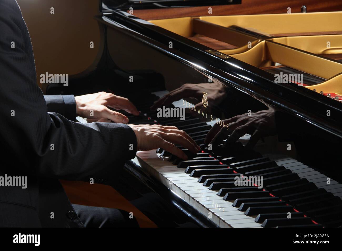 Mani pianiste maschili che suonano su una Steinway di classe mondiale e Sons piano tasti in bianco e nero ad Atene, in Grecia. Foto Stock