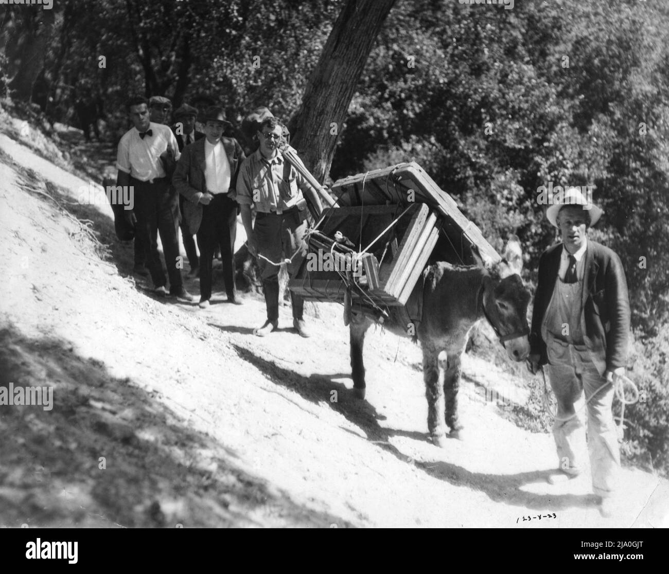 Assistente direttore WILLIAM A.WELLMAN (bowtie) appena dietro l'uomo leader JACK PICKFORD e cameraman ERNEST MILLER in posizione set candid ascendente Mount Lowe in San Gabriel Mountains, California durante le riprese di JUST OUT OF COLLEGE 1920 regista ALFRED E. GREEN Goldwyn Pictures Corporation Foto Stock