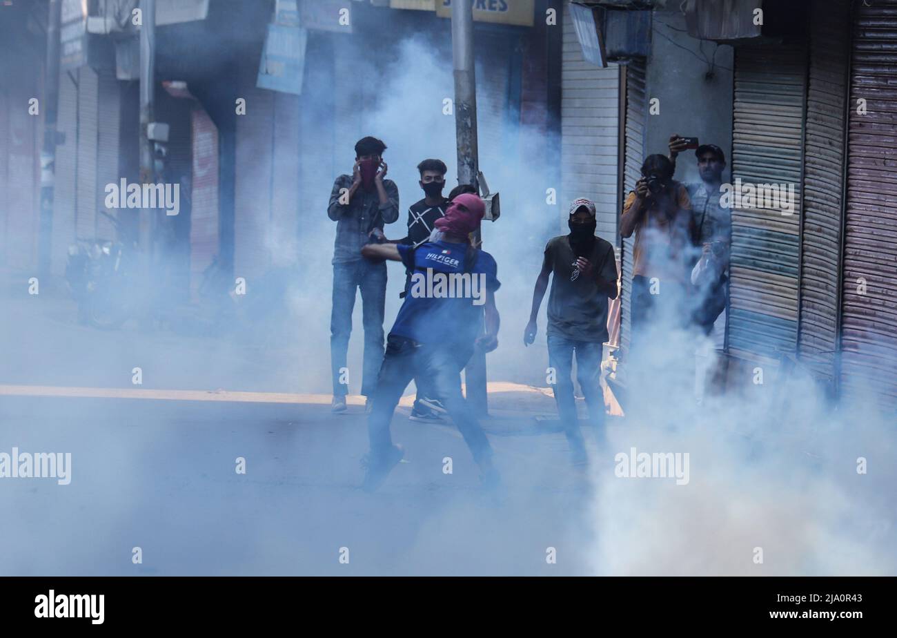 I manifestanti prendono parte a una manifestazione tra il fumo di lacrima sparato dalle forze di sicurezza indiane per disperderli a Srinagar il 25 maggio 2022, durante l'audizione di condanna del partito pro-indipendenza Jammu Kashmir presidente del fronte di liberazione Yasin Malik. Proteste Clashe erutta a Srinagar come NIA Court premia la condanna a vita al separatista Yasin Malik. Malik, uno dei leader ribelli del Kashmir amministrati dall'India, è il capo del fronte di liberazione ora bandito di Jammu e Kashmir (JKLF). Il gruppo ha rinunciato alla violenza nel 1994. (Foto di Sajad Hameed/INA Photo Agency/Sipa USA) Foto Stock