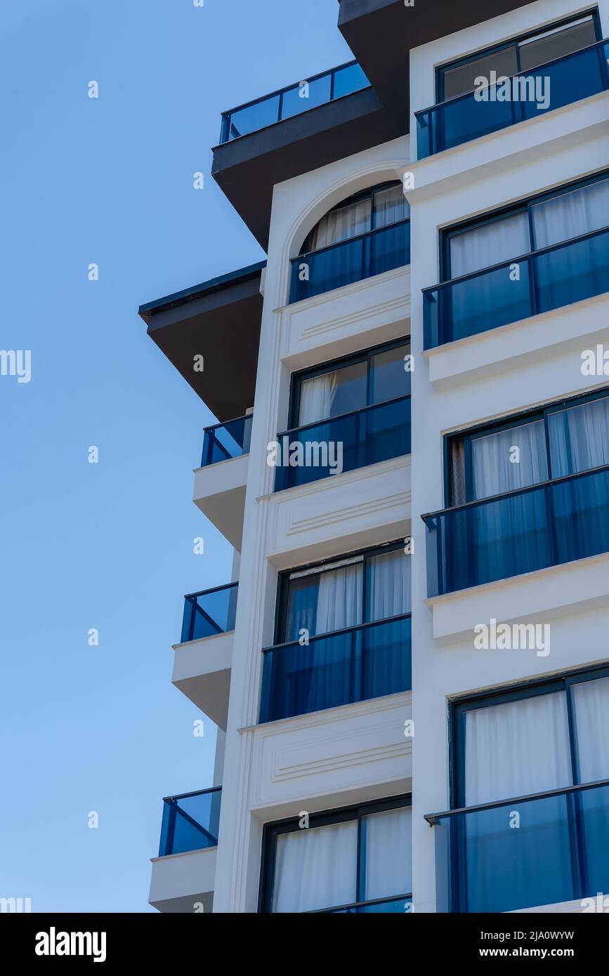 Frammento di un moderno appartamento residenziale, il concetto di costruzione di una casa. Moderno edificio residenziale in una giornata di sole con cielo blu. Foto Stock