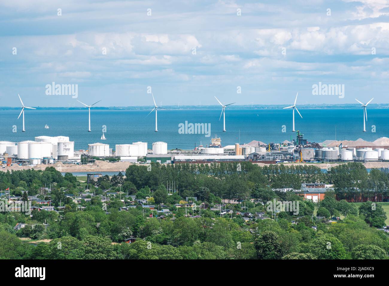 Veduta d'areale dell'energia delle turbine eoliche offshore in una fila nel Mar Baltico in un distretto industriale di Copenhagen, Danimarca Foto Stock